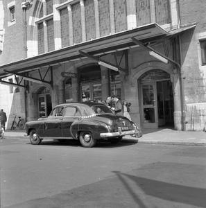 150364 Afbeelding van een taxi voor de ingang van het N.S-station Haarlem te Haarlem.